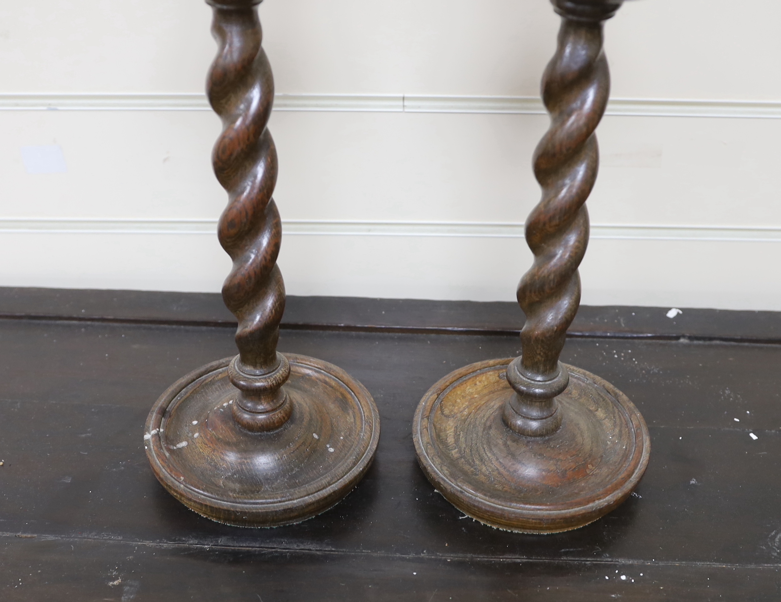A pair of early 20th century spiral turned candlesticks with brass sconces, height 38cm